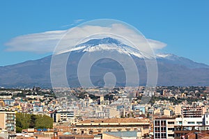 Majestic Mount Etna volcano with Italian city Catania at the foot of the mountain. Snow on the very top of the volcano