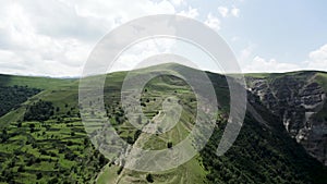 Majestic mountain aerial landscape with pine forest on a summer sunny day. Action. Green mountain ridge on cloudy sky