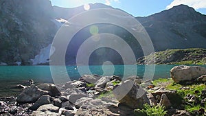 Majestic mountain lake scenery, rocks in blue water, sunshine