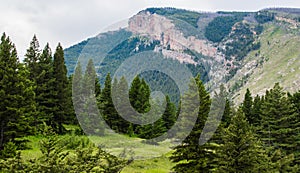 Majestic mountain peak and sloping hillside covered with lush forest near Bozeman, Montana photo