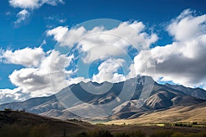 majestic mountain range in the daytime, with blue skies and puffy clouds