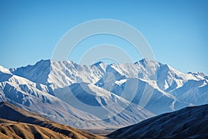 majestic mountain range, with snow-capped peaks and clear blue skies