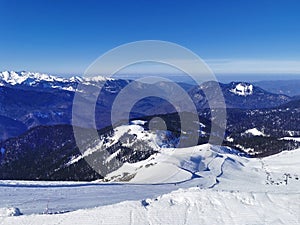 Majestic mountain ski slopes under a clear blue sky.