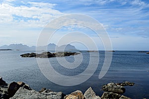 Majestic ocean landscape with many small rocky islands and mountain backdrop