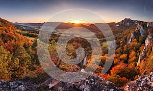 Majestic particolored forest with sunny beams. Natural park. Dramatic unusual scene. Red and yellow autumn leaves. Carpathians,