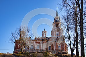 A majestic red brick temple against a bright blue sky