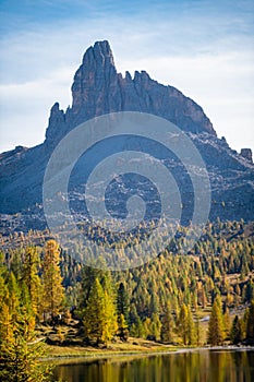 Majestic rock peak above golden larch forest in Italy\'s Dolomites