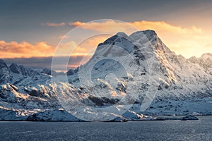 Majestic scene with high snow covered mountains at sunset