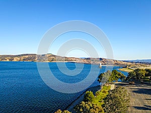 A majestic shot of the still deep blue lake waters, gorgeous mountain ranges and blue sky at Castaic Lake photo