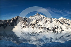 Majestic snow covered mountains reflecting in the water