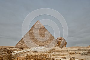 Majestic sphinx sculpture stands guard in front of the iconic pyramids of Giza, Egypt.