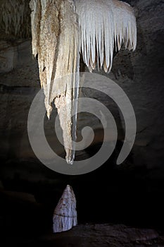 Majestic Stalactite and Stalagmite Formation in a Dark Cave