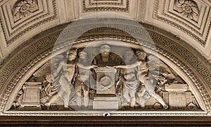 Majestic stone and stucco statue stands proudly above the entrance to an old museum photo