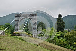 Majestic stony bridge for pedestrians spanning over the green valley in Nikko, Japan