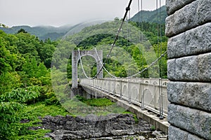 Majestic stony bridge for pedestrians spanning over the green valley in Nikko, Japan