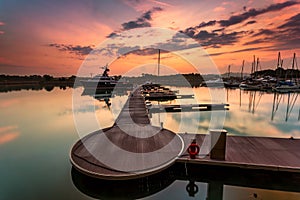 A majestic sunrise with boat resting near the dock as foregrou