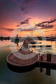 A majestic sunrise with boat resting near the dock as foregrou