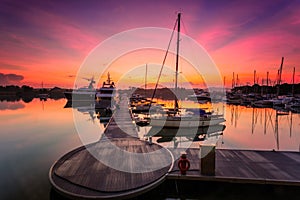 A majestic sunrise with boat resting near the dock as foregrou