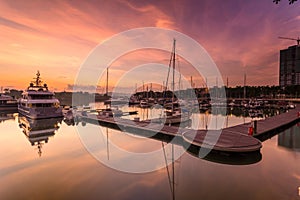 A majestic sunrise with boat resting near the dock as foregrou