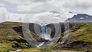 Majestic Svoedufoss waterfall in front of the Snaefellsjoekull glacier in Iceland