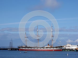 Majestic Three-Masted Sailing Ship Docked at a Sunny Coastal Harbour