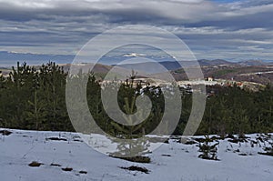 Majestic view of cloudy sky, winter mountain, snowy glade, residential district, conifer and deciduous forest from Plana mountain