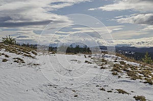 Majestic view of cloudy sky, winter mountain, snowy glade, residential district, conifer and deciduous forest from Plana mountain