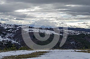 Majestic view of cloudy sky, winter mountain, snowy glade, residential district, conifer and deciduous forest from Plana mountain