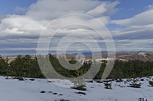 Majestic view of cloudy sky, winter mountain, snowy glade, residential district, conifer and deciduous forest from Plana mountain