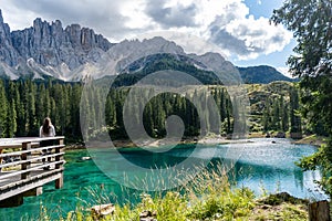 Majestic view of Lake Karersee in the Dolomites, Italy, with a girl admiring the scenery