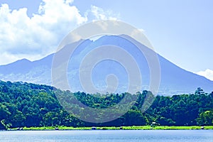 a majestic volcano with a calm lake in front of it.