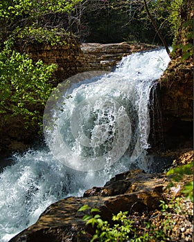 Majestic waterfall cascading over rocks into a peaceful forest