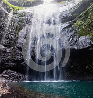 Majestic waterfall flowing on rocky cliff in tropical rainforest