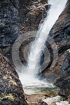 Waterfall near hiking trail in Bavarian alps. Travel nature destinations concept