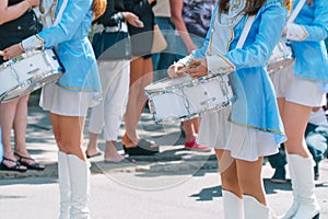 Majorettes and marching band. Young girls drummer at the parade. Street performance