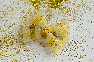 Makaroni bow shape in tinsels on white background