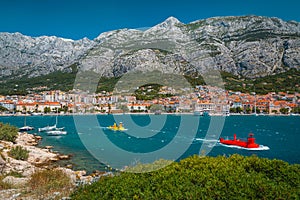 Makarska cityscape view with blue bay and small submarine watercrafts