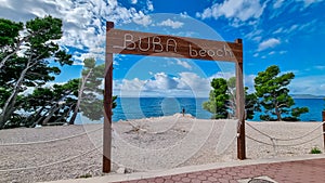 Makarska - Wooden sign indicating the entrance to idyllic Buba beach along Makarska Riviera, Split-Dalmatia, Croatia, Europe