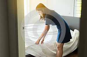 Make a bed,Asian women making her bed in room after wake up in the morning