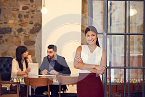 We make big things happen every day in this office. Portrait of a young businesswoman standing in an office with her