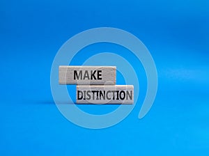 Make distinction symbol. Concept words make distinction on wooden blocks. Beautiful blue background. Business and make distinction