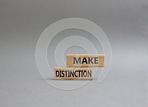 Make distinction symbol. Concept words make distinction on wooden blocks. Beautiful grey background. Business and make distinction