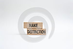 Make distinction symbol. Concept words make distinction on wooden blocks. Beautiful white background. Business and make