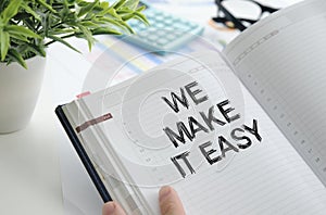 We make it easy text on white notepad paper in hand on white background