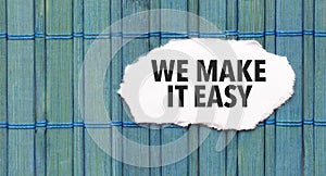 we make it easy word on torn paper with blue wooden background