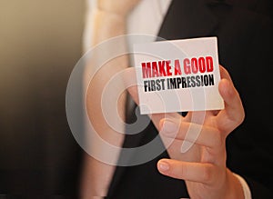 Make a good first impression on a card Businessman holding. Motivation and personal coaching concept