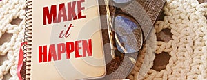 Make it happen message on the cover of spiral notebook with eyeglases and pen. Business motivation concept