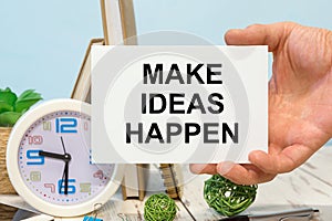 MAKE IDEAS HAPPEN text on the card in hand