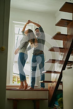 We make it look easy. an affectionate young couple at home dancing together.