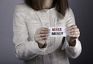 Make Money. Businesswoman holding a card with a message text written on it. .
